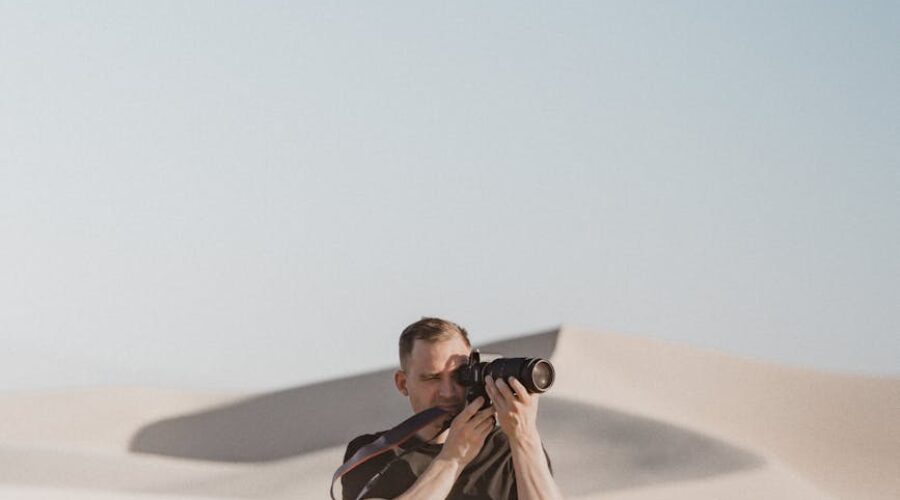 man taking picture with camera on desert