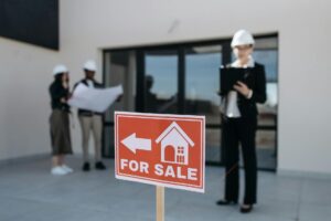 red for sale sign by house