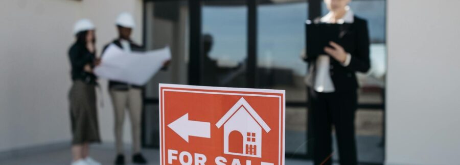 red for sale sign by house