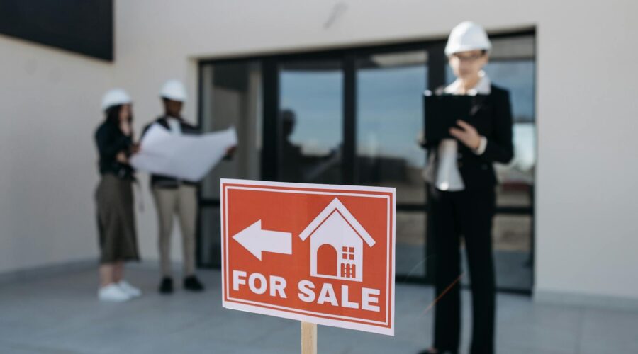 red for sale sign by house