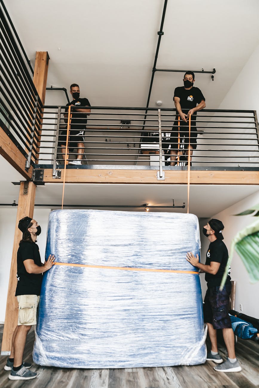 workers lifting heavy box with straps