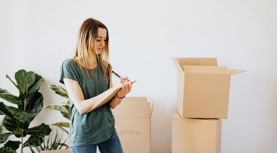 glad woman writing down notes during while packing