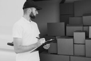 grayscale photo of man looking at boxes